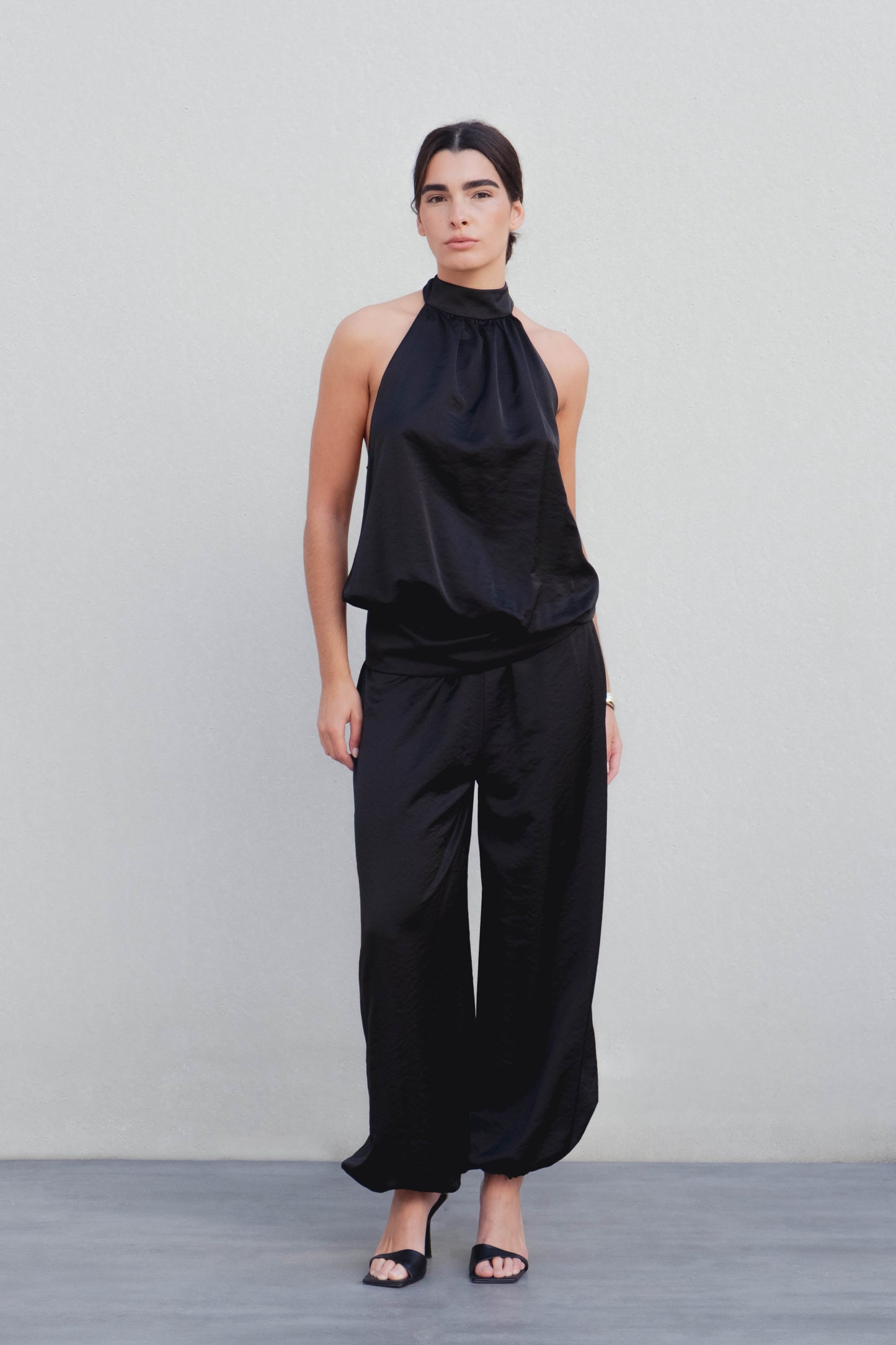 Pantalón bombacho satinado negro con puño elástico diseño español