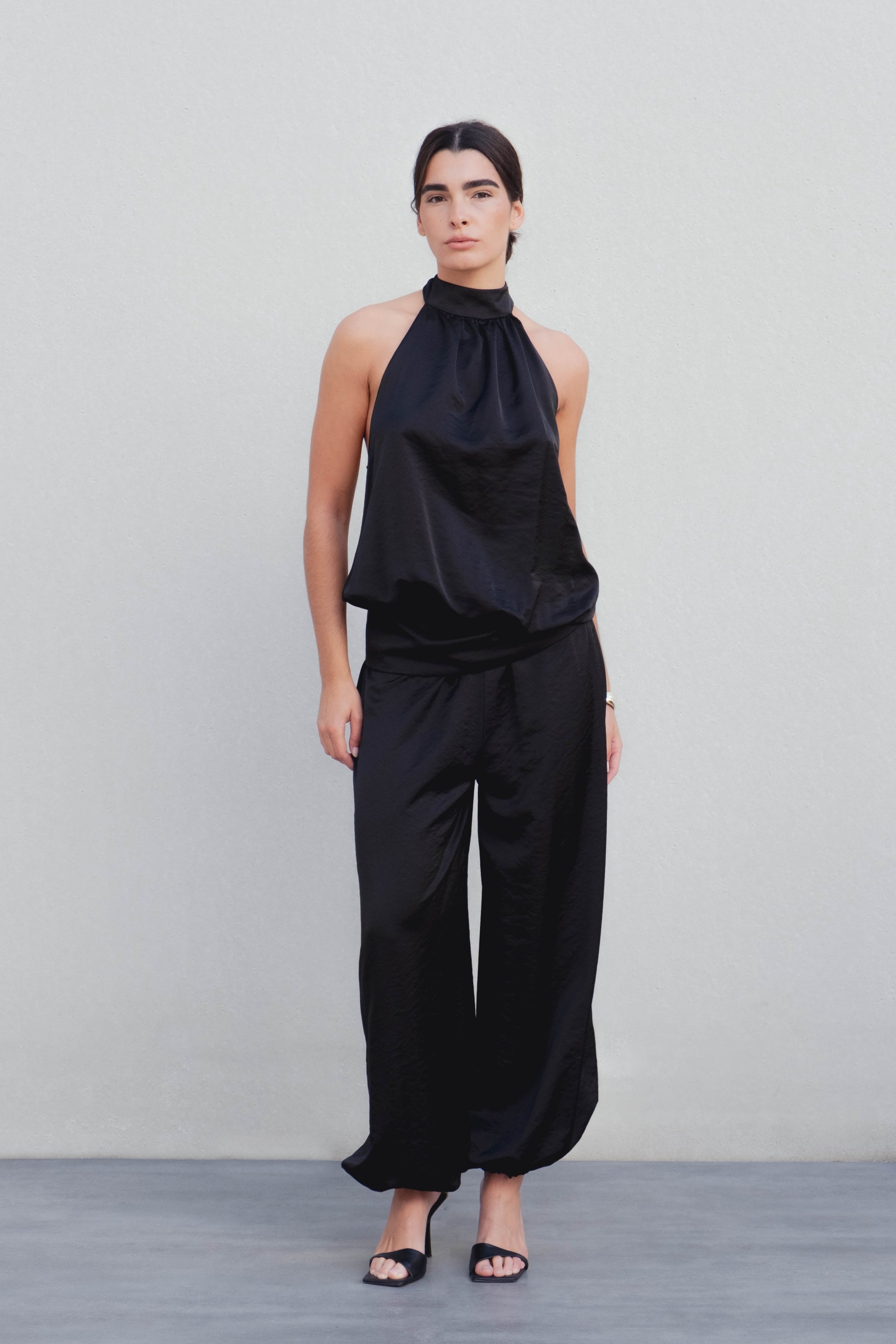 Pantalón bombacho satinado negro con puño elástico diseño español