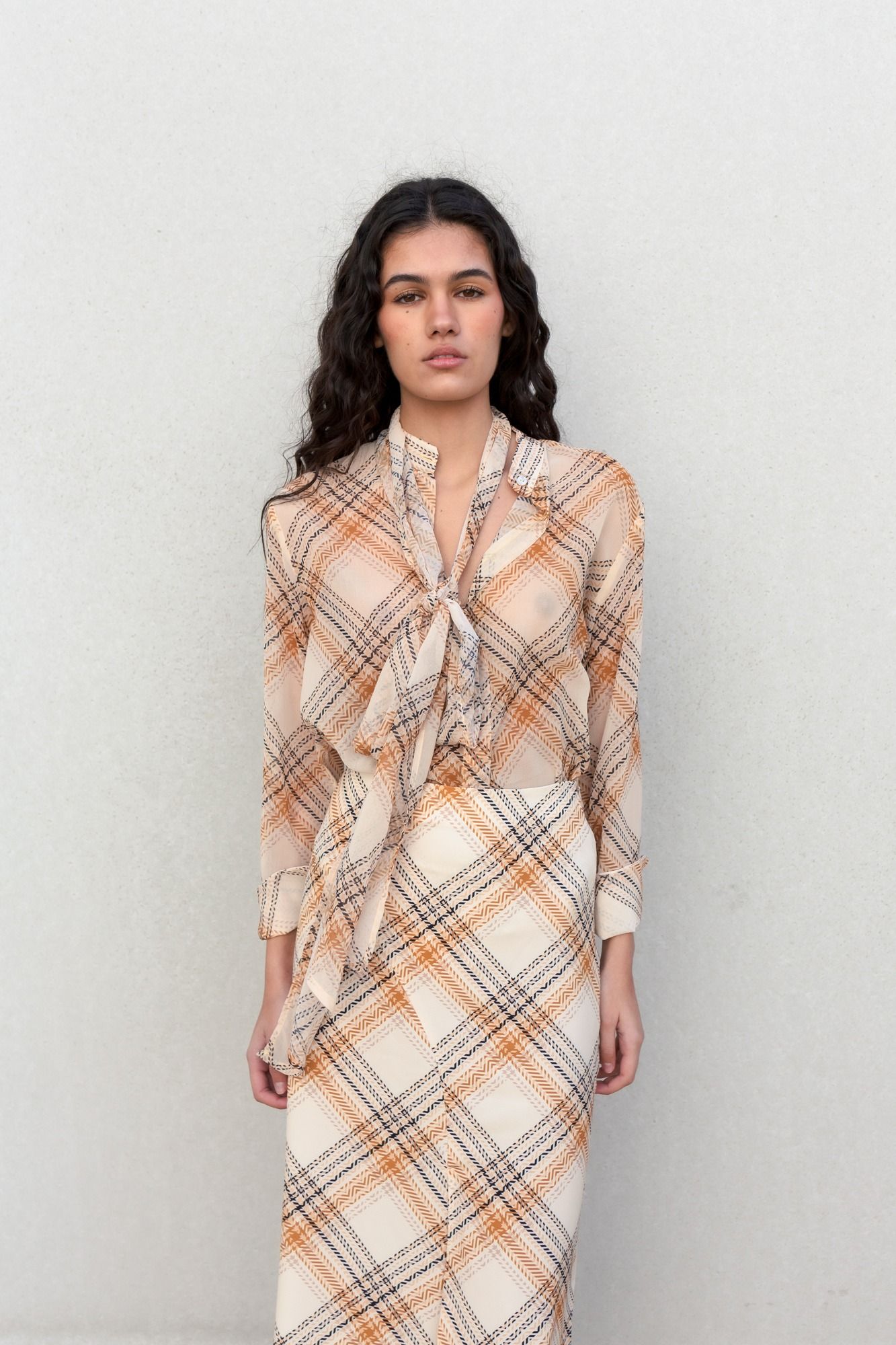Blusa satinada fluida de mangas abullonadas con lazada al cuello y estampado a cuadros en color beige