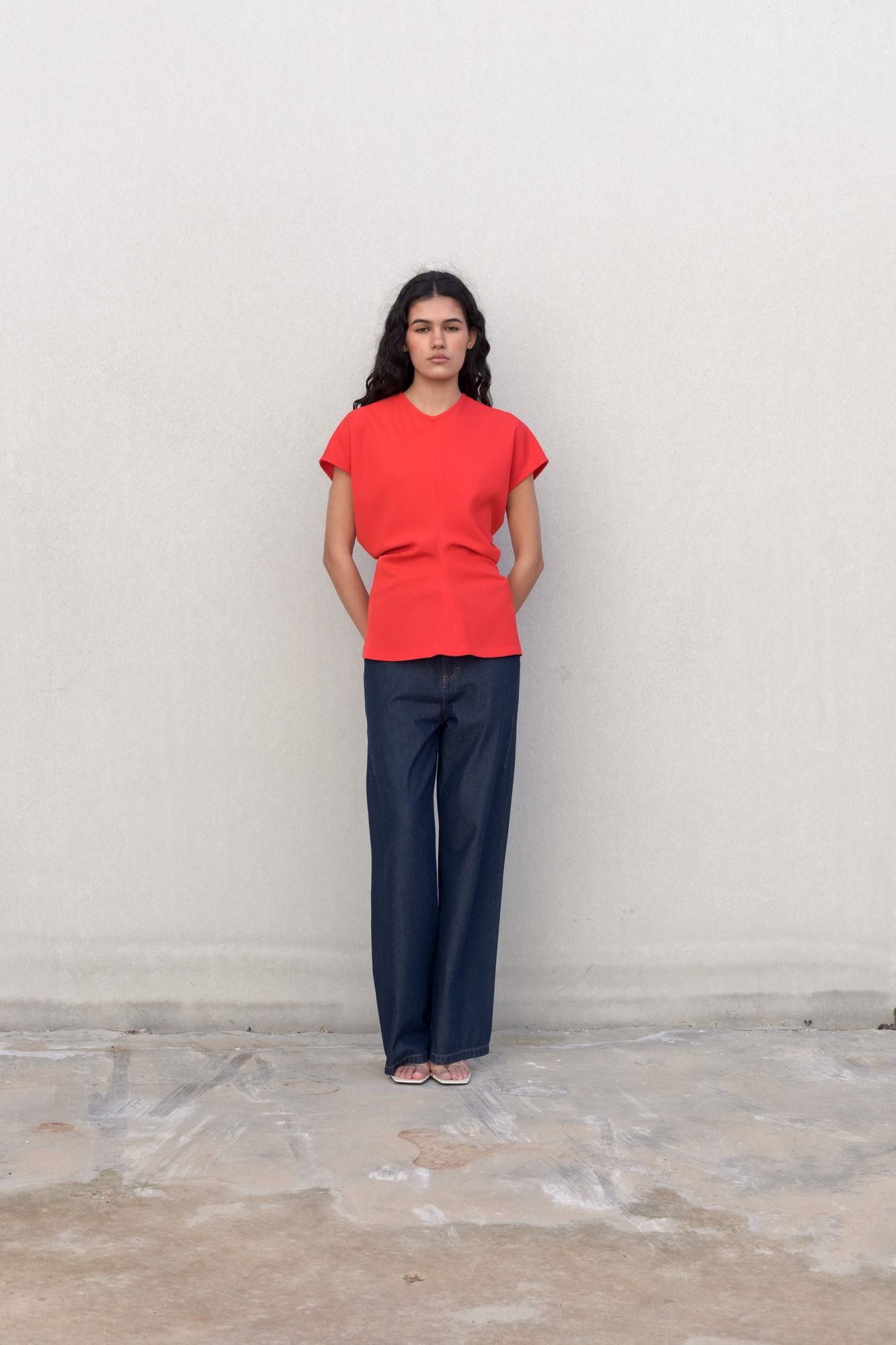 Blusa fluida para mujer en color rojo intenso con diseño texturizado de frunces frontales y mangas largas.