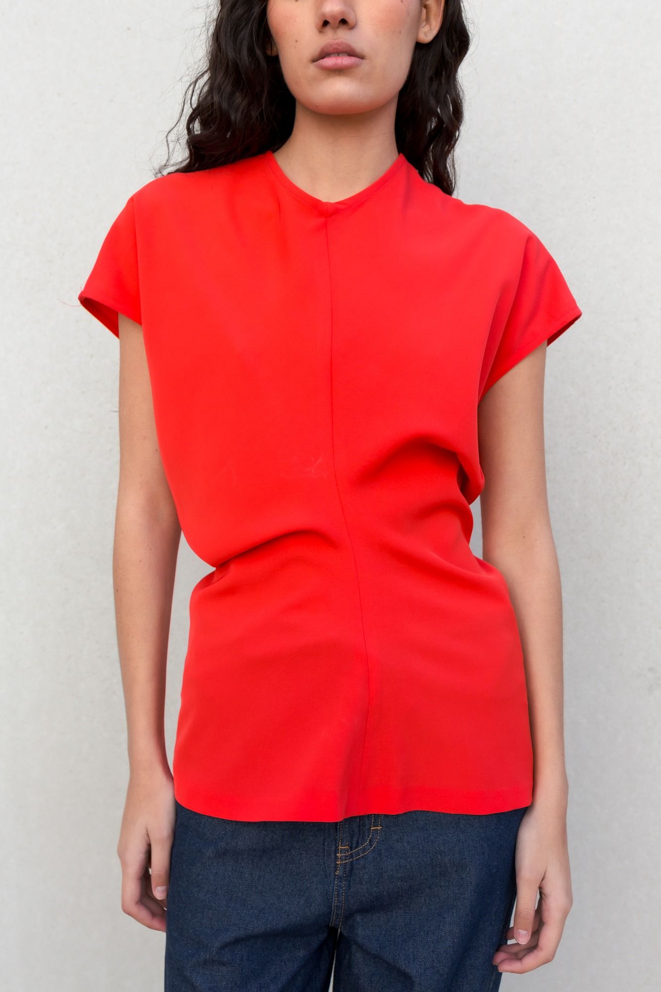 Blusa fluida para mujer en color rojo intenso con diseño texturizado de frunces frontales y mangas largas.
