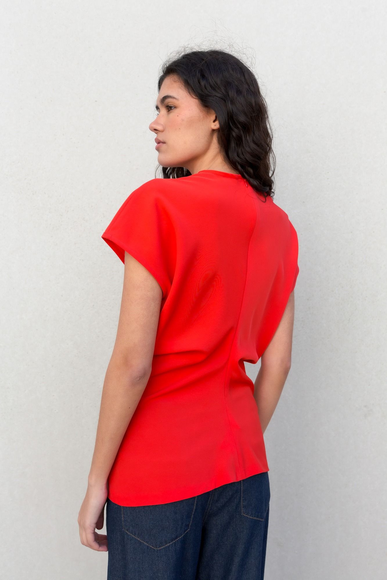 Blusa fluida para mujer en color rojo intenso con diseño texturizado de frunces frontales y mangas largas.