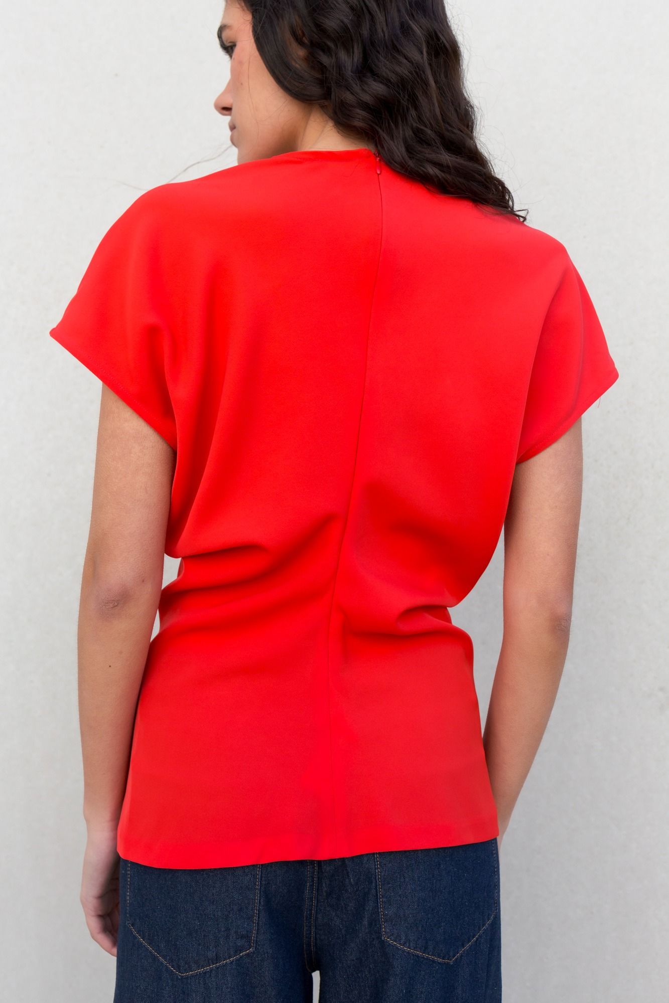 Blusa fluida para mujer en color rojo intenso con diseño texturizado de frunces frontales y mangas largas.