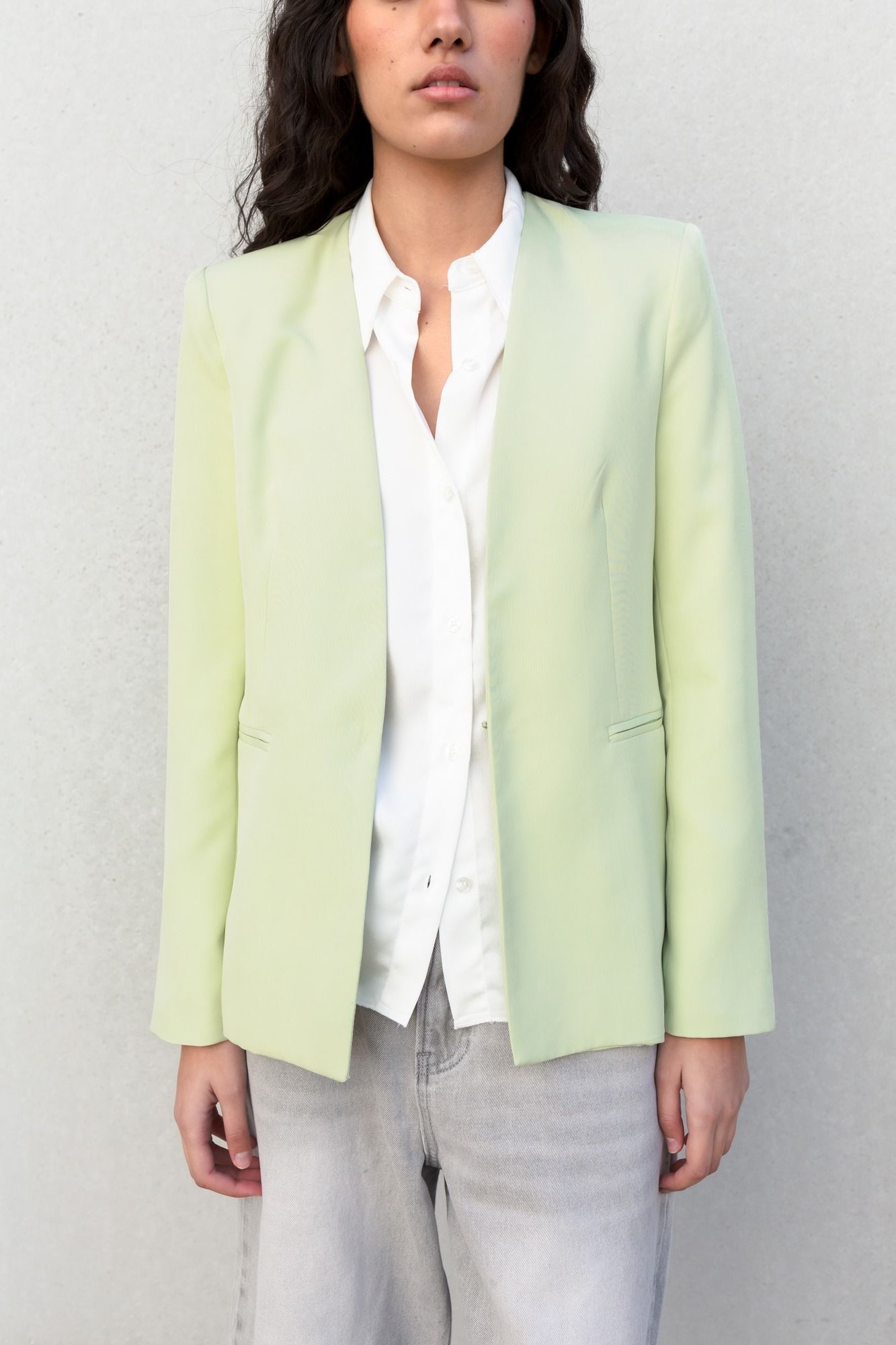 Chaqueta blazer minimalista en color verde sin solapas con cuello de pico estilizado