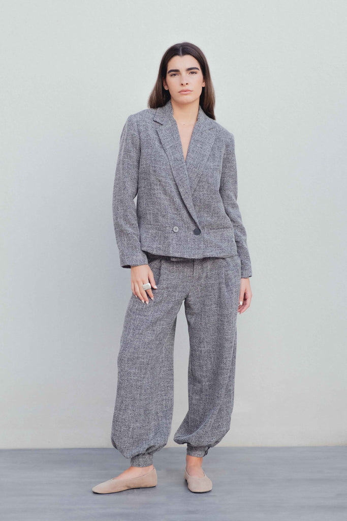 Blazer de estructura negra, corte cropped y cierre cruzado