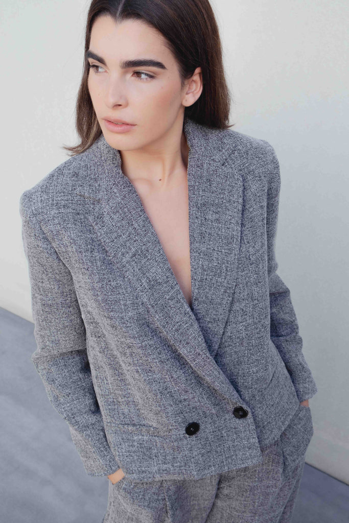 Blazer de estructura negra, corte cropped y cierre cruzado