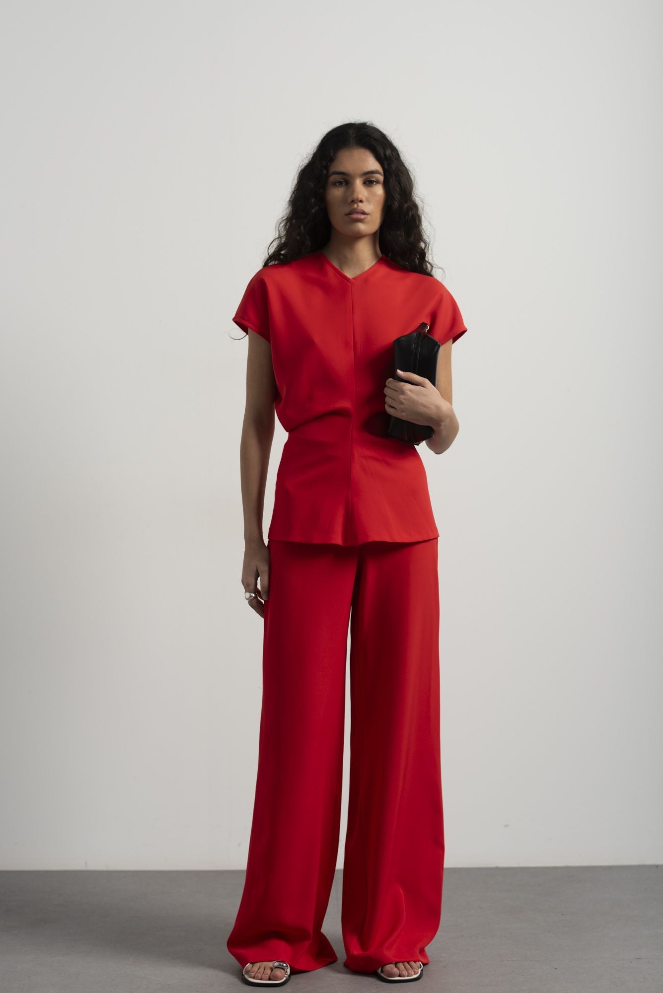 Blusa fluida para mujer en color rojo intenso con diseño texturizado de frunces frontales y mangas largas.