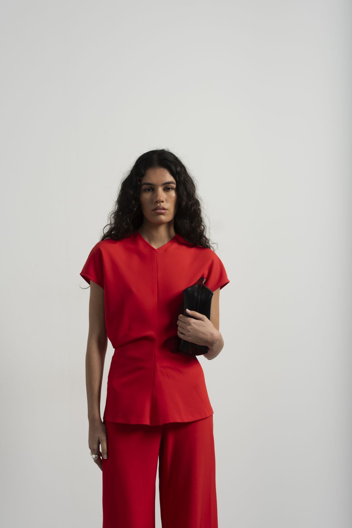 Blusa fluida para mujer en color rojo intenso con diseño texturizado de frunces frontales y mangas largas.