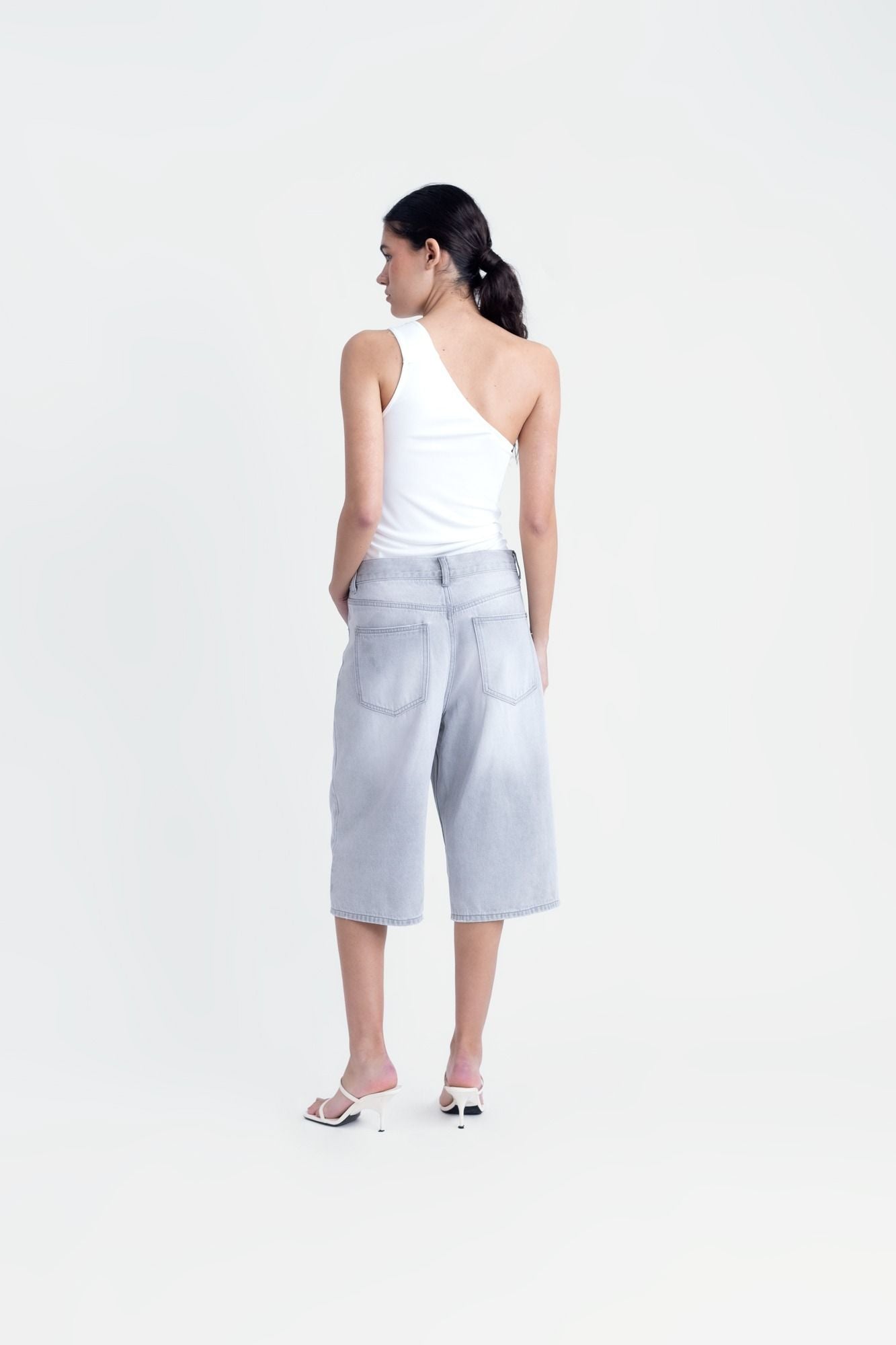Top corto para mujer en color crudo con diseño asimétrico de un solo hombro y silueta ajustada de fiesta.